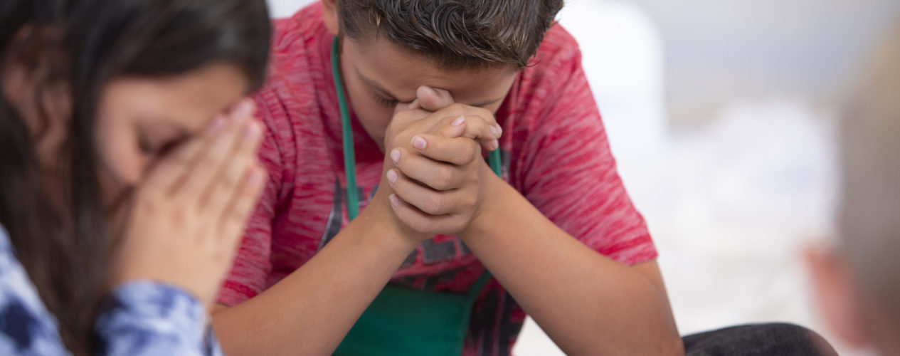 boy and girl in prayer with their small group