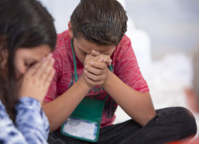 boy and girl in prayer with their small group