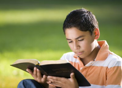 child reading the Bible outside