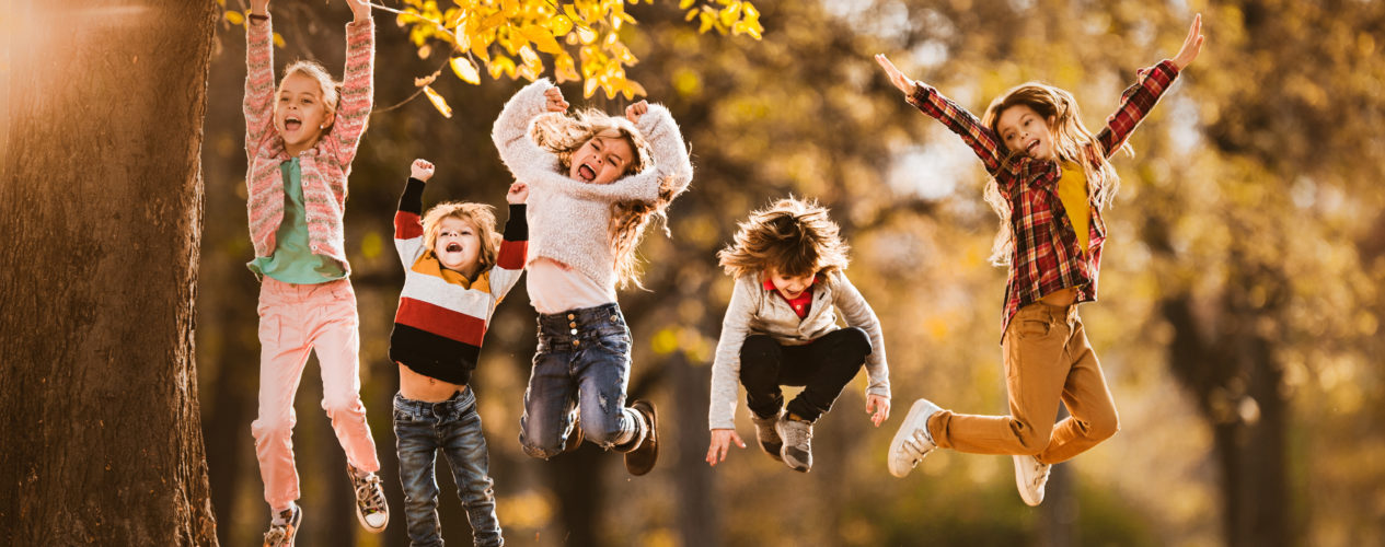 kids jumping in fall leaves