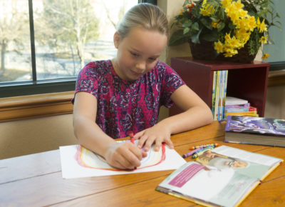 girl coloring a coloring creation page