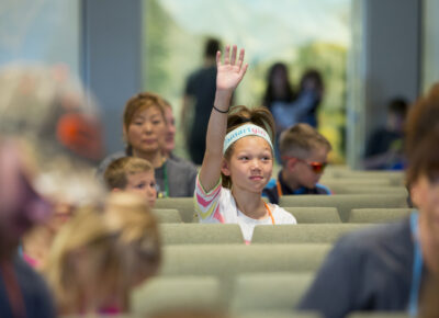 preteen girl raising hand with question
