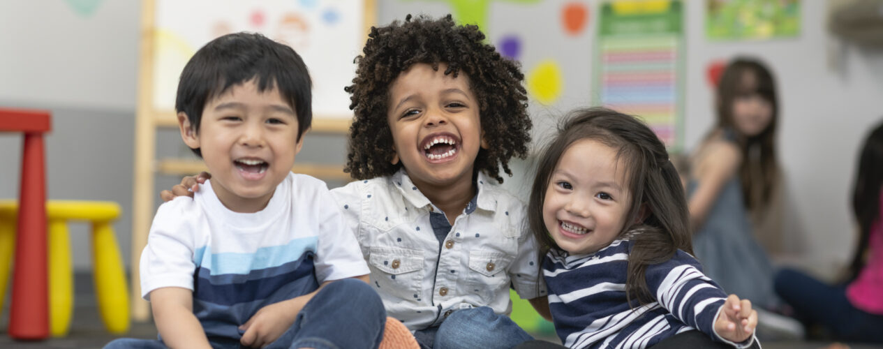 group of three smiling preschoolers