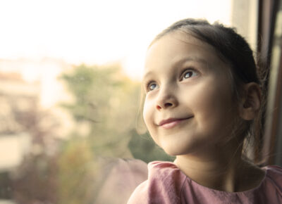 girl smiling while looking out window