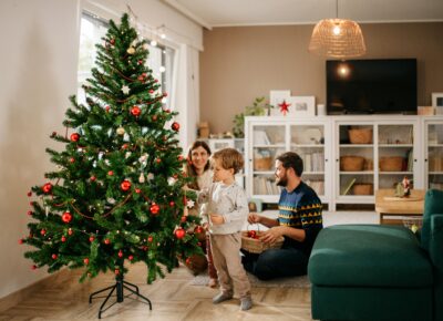 family decorating with Christmas tree ornaments