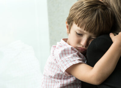 a sad child hugging a parent