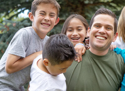 Dad with kids smiling and having fun outside