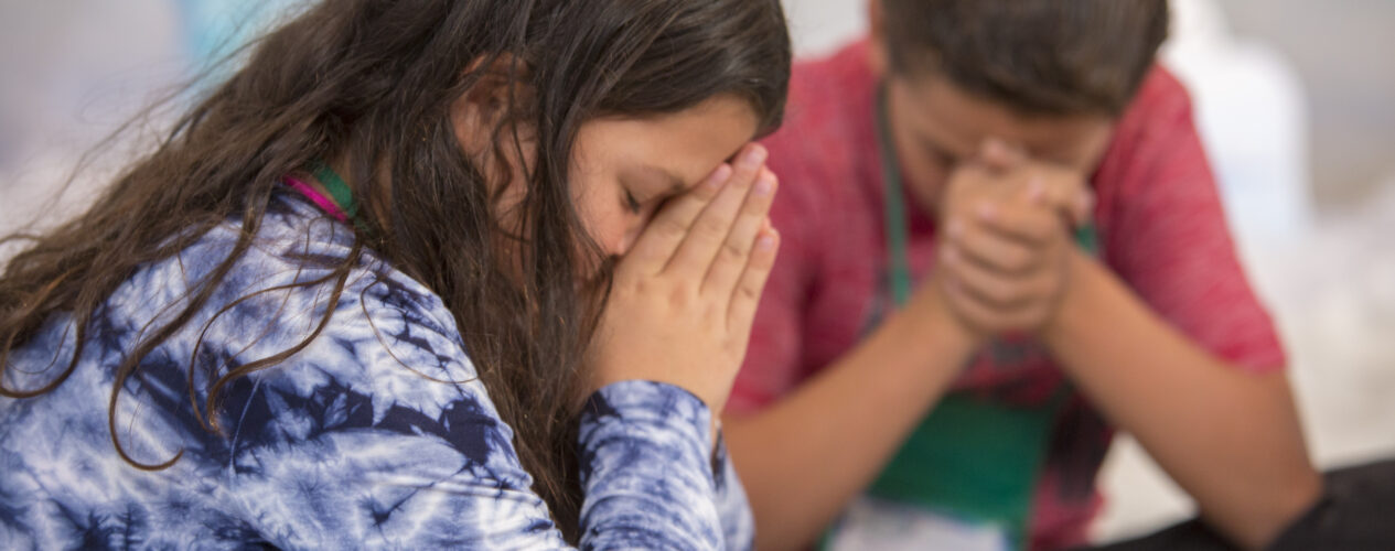 kids praying during Bible lesson
