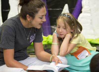 Teacher helping child with Bible memory