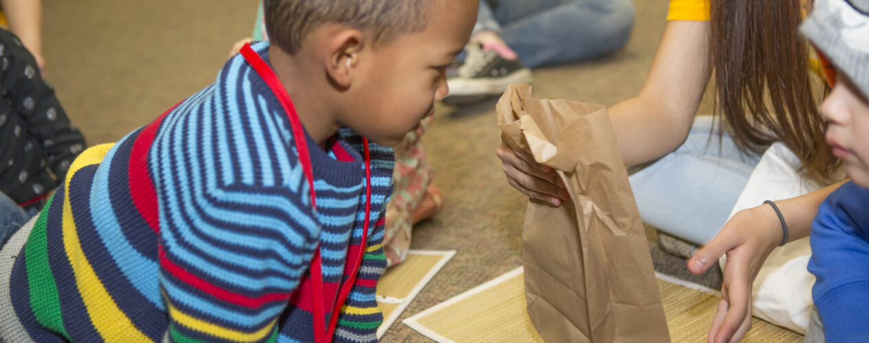Child playing mystery object game to practice courage.