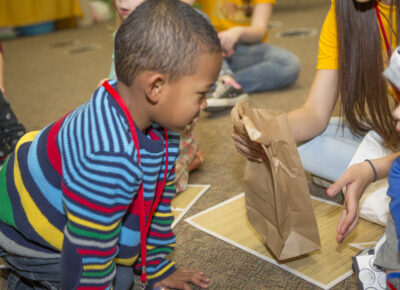 Child playing mystery object game to practice courage.