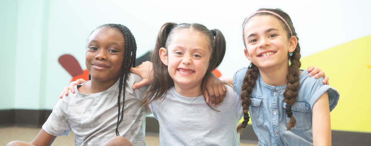 Girls smiling after playing a game that reminds kids to give thanks
