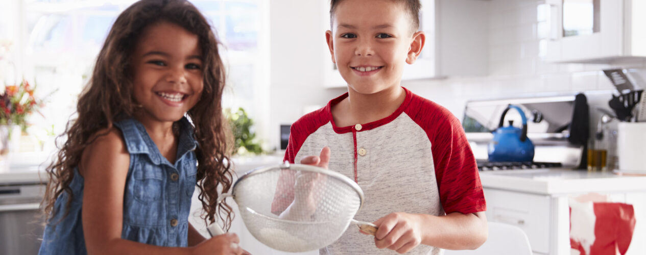 Kids smiling together as they make a Thanksgiving snack.