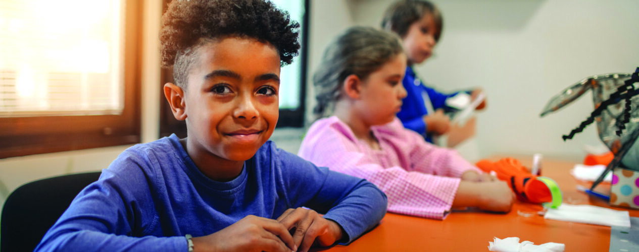 a elementary boy in kid's ministry making a craft for Thanksgiving