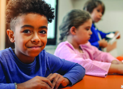 a elementary boy in kid's ministry making a craft for Thanksgiving