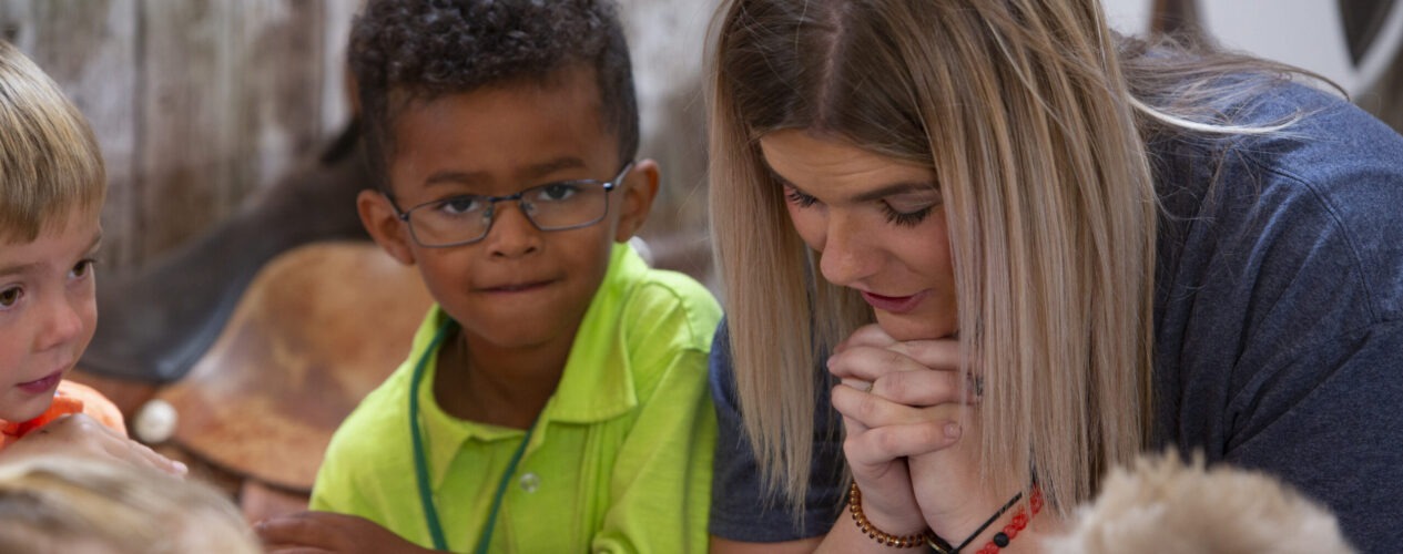 Leader and kid participating in one of the prayer ideas.
