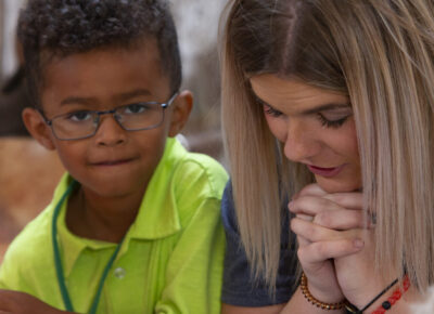 Leader and kid participating in one of the prayer ideas.