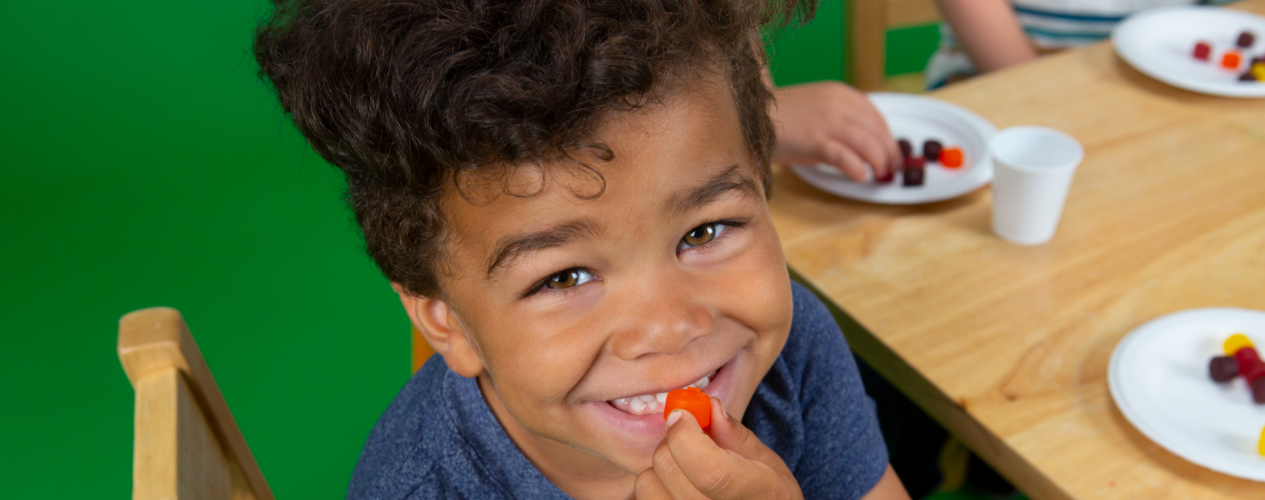 kid at children's church eating a fruit snack and smiling