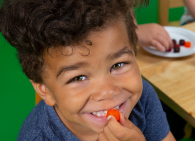 kid at children's church eating a fruit snack and smiling