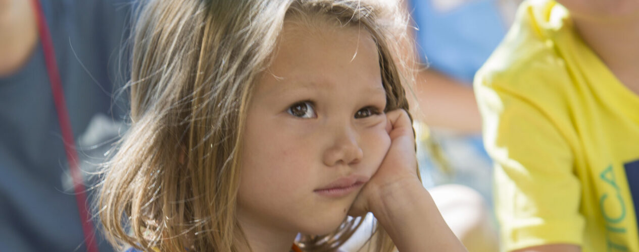 elementary age girl listening to a ministry sermon but who is clearly very bored.