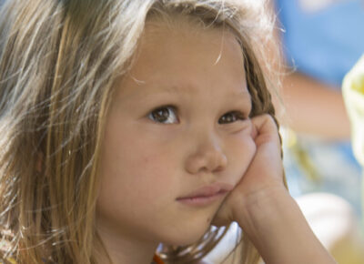elementary age girl listening to a ministry sermon but who is clearly very bored.