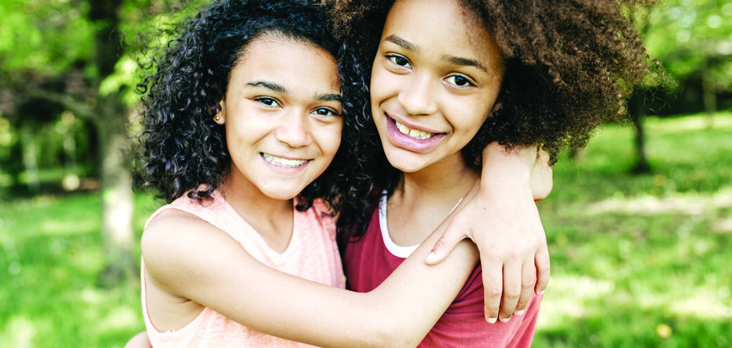 two girls from children's church hugging