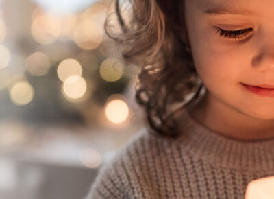 child looking in awe at a Christmas candle
