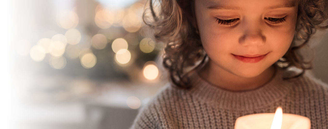 child looking in awe at a Christmas candle